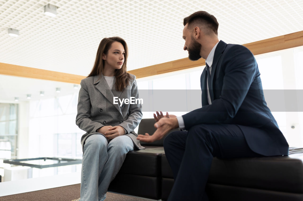 Business colleagues discussing sitting on couch