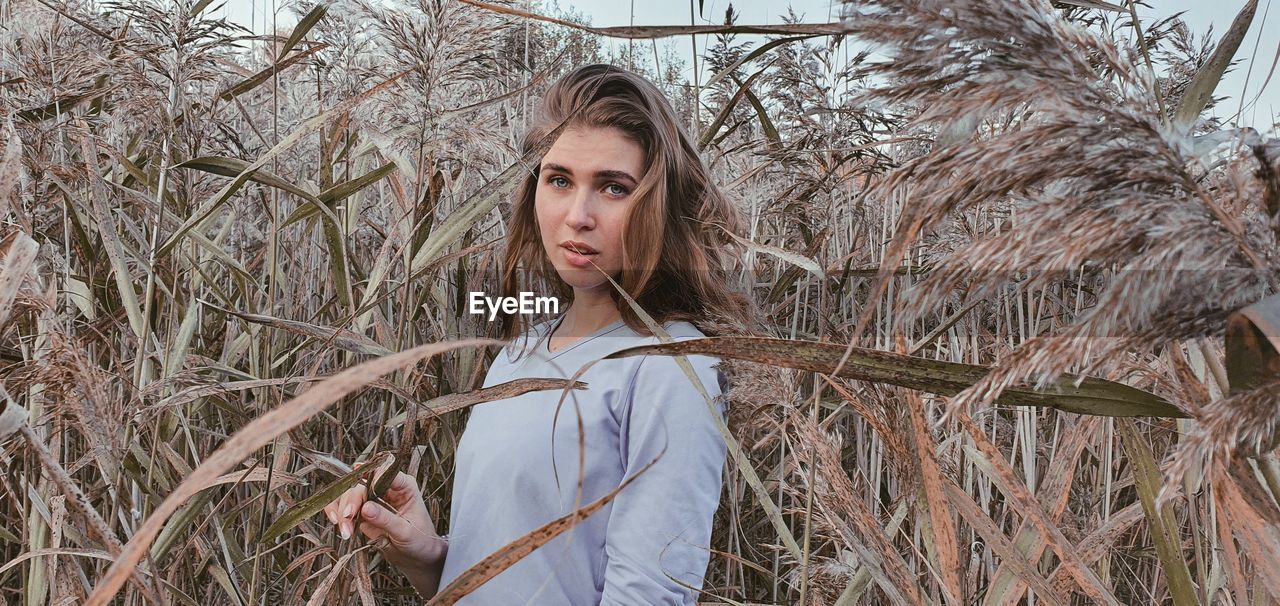 Portrait of woman standing by plants