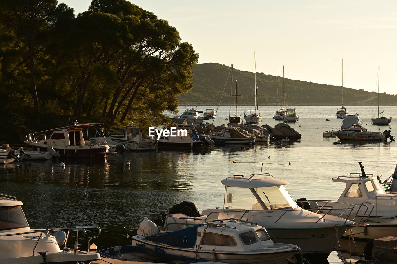 Boats in sea at sunset