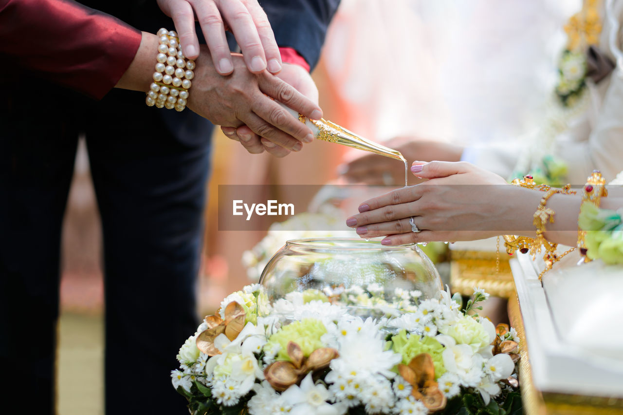 Parents pouring water on bride hands