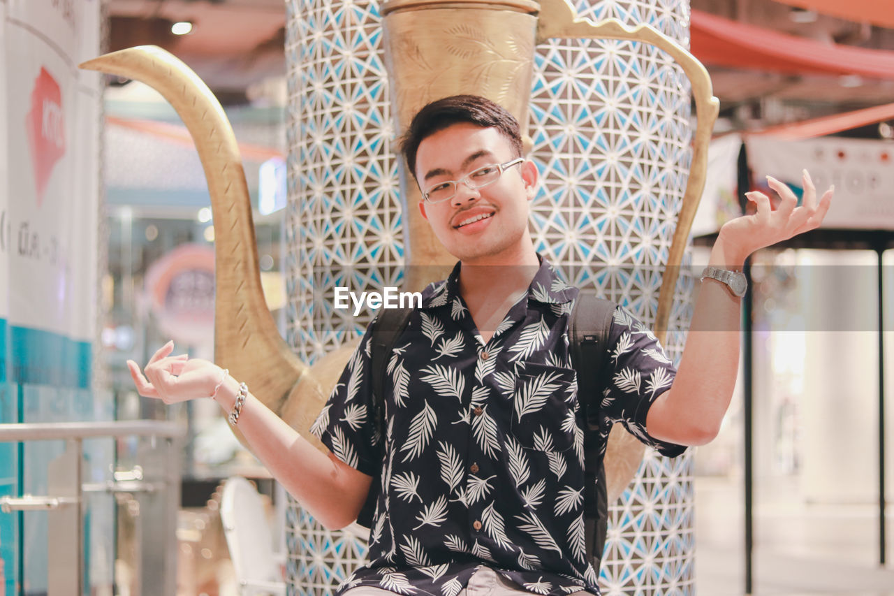 Smiling young man standing in column