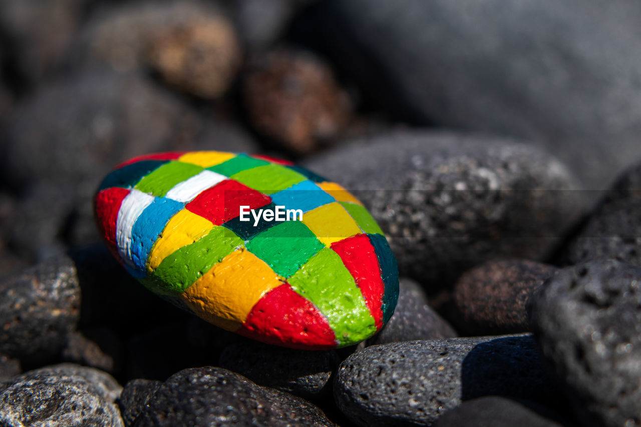 CLOSE-UP OF MULTI COLORED STONES ON ROCK