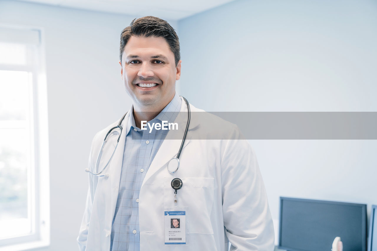 Portrait of happy doctor standing in hospital