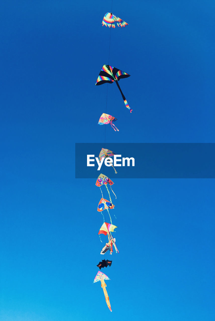 Low angle view of kite against clear blue sky