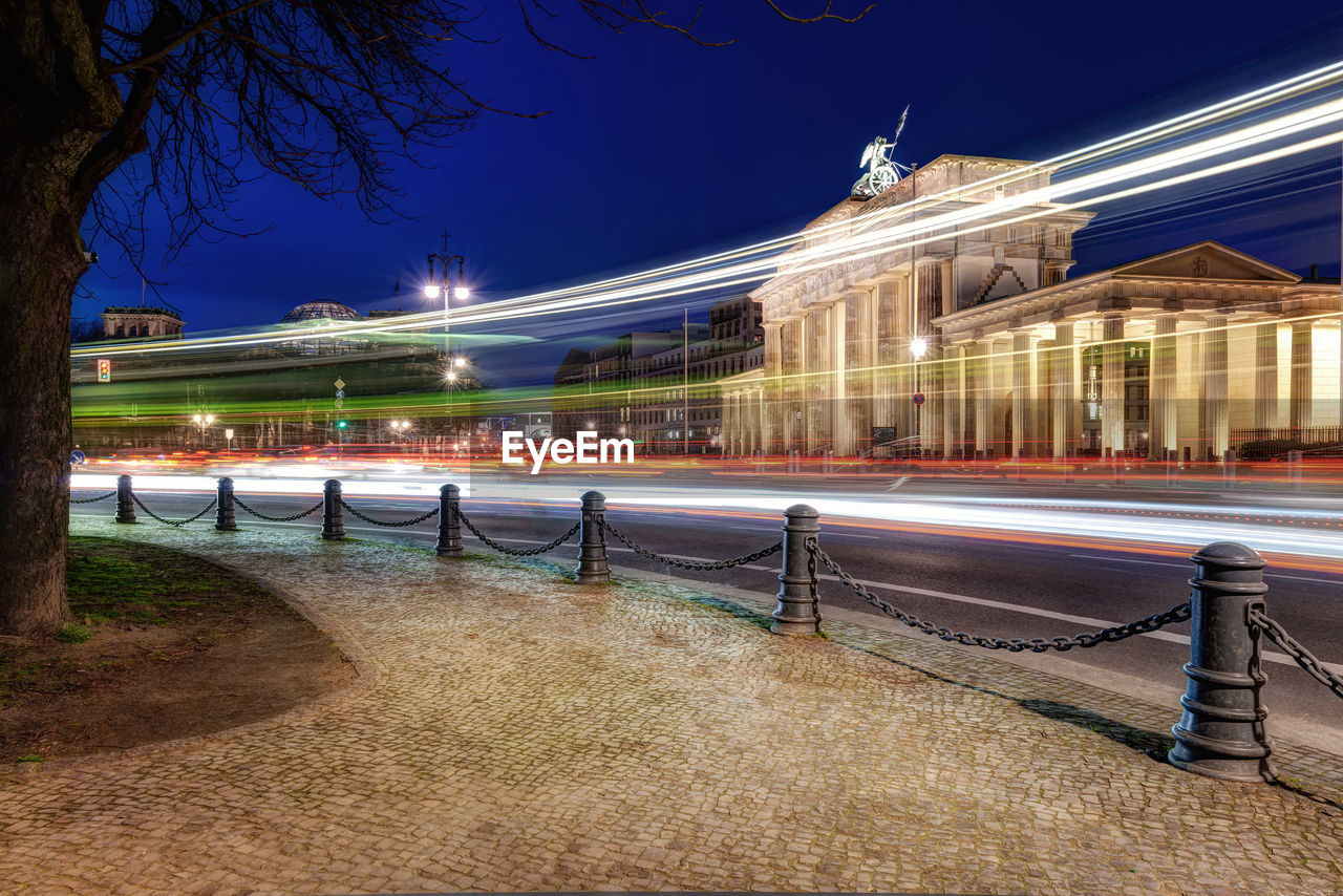 Light trails in city against clear sky at night