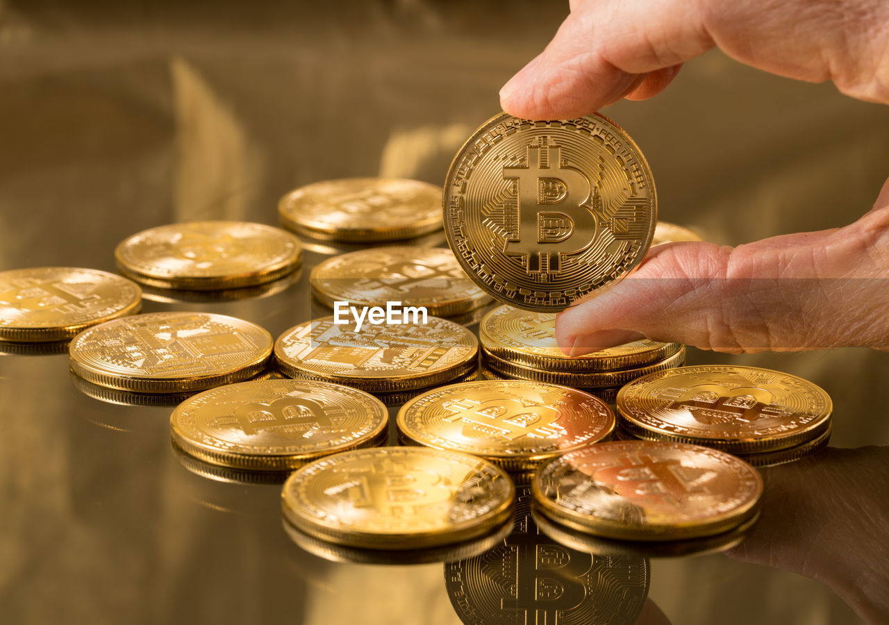 CLOSE-UP OF HAND HOLDING COINS WITH CANDLES