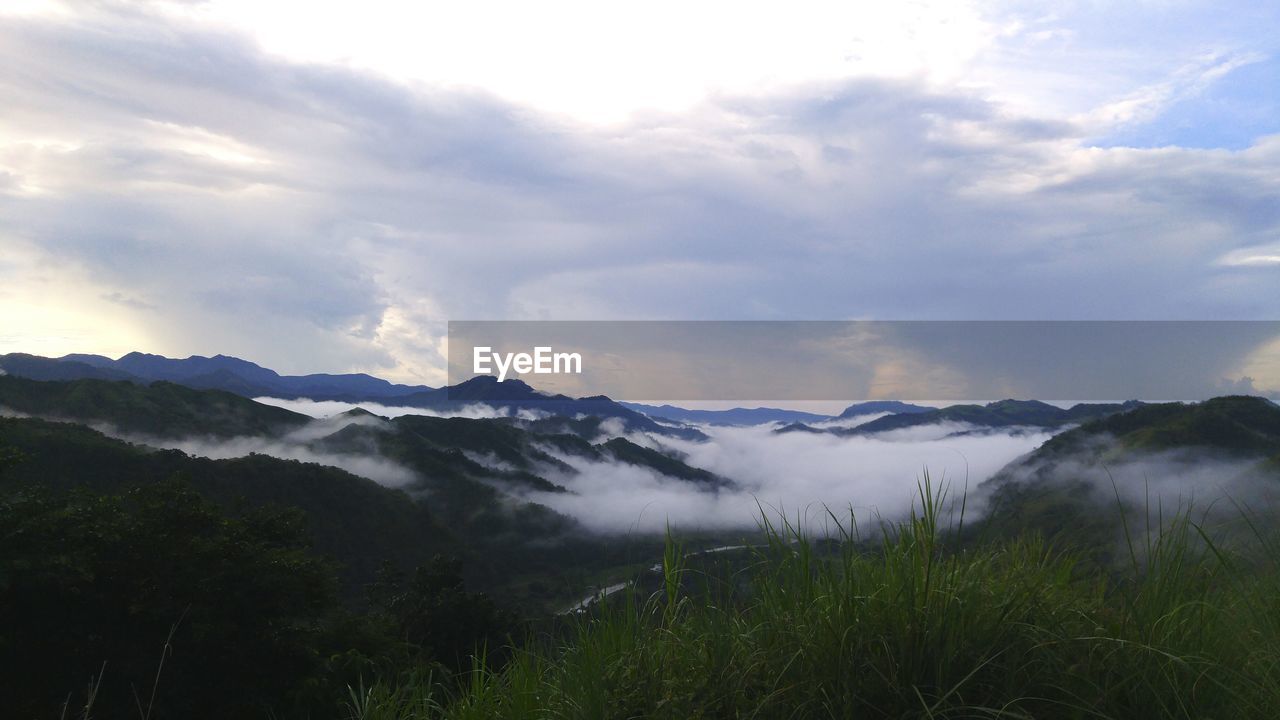 Scenic view of mountains against cloudy sky