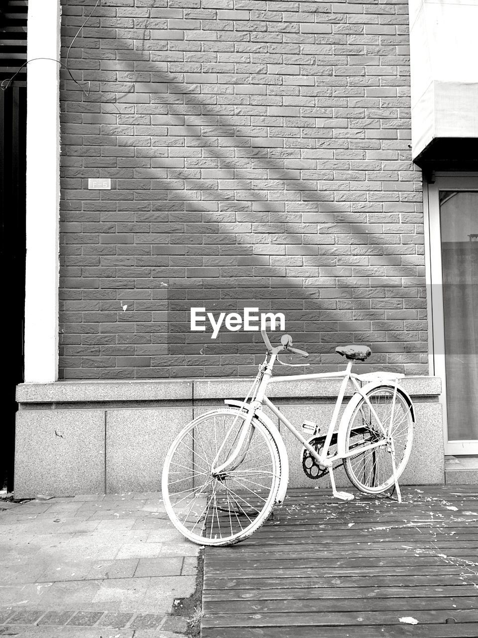 BICYCLE PARKED AGAINST BUILDING