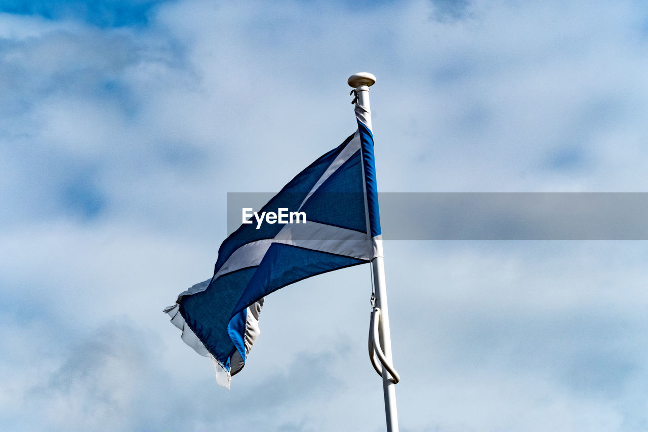LOW ANGLE VIEW OF FLAGS HANGING AGAINST SKY