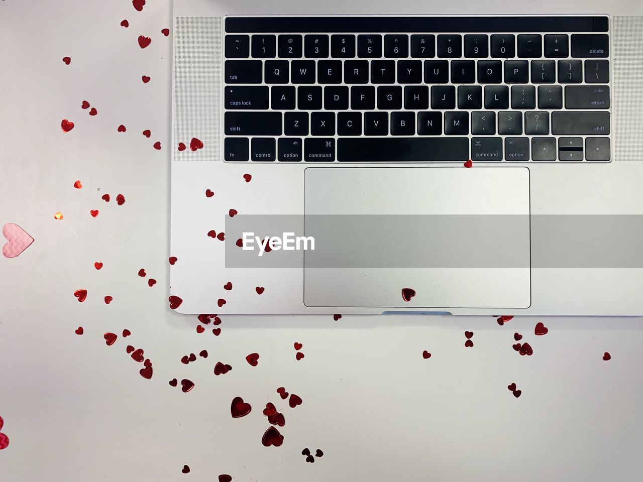 High angle view of heart shaped paper pieces on computer keyboard