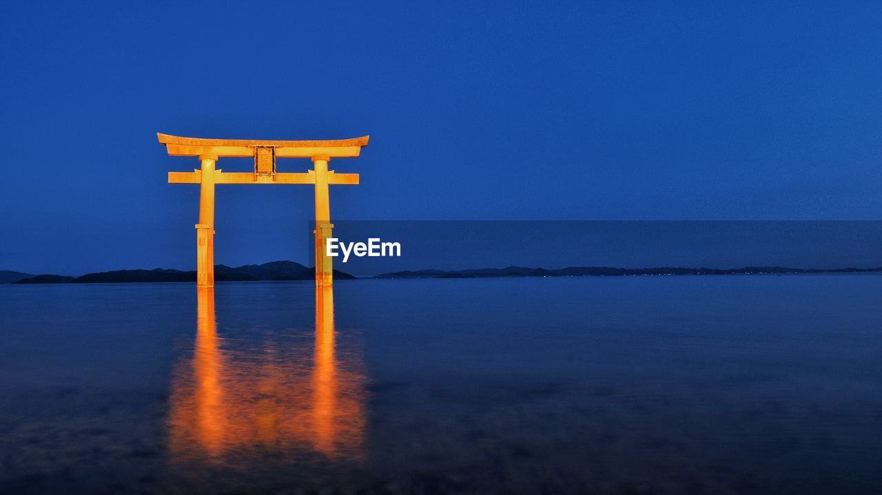 Scenic view of sea against clear blue sky at night