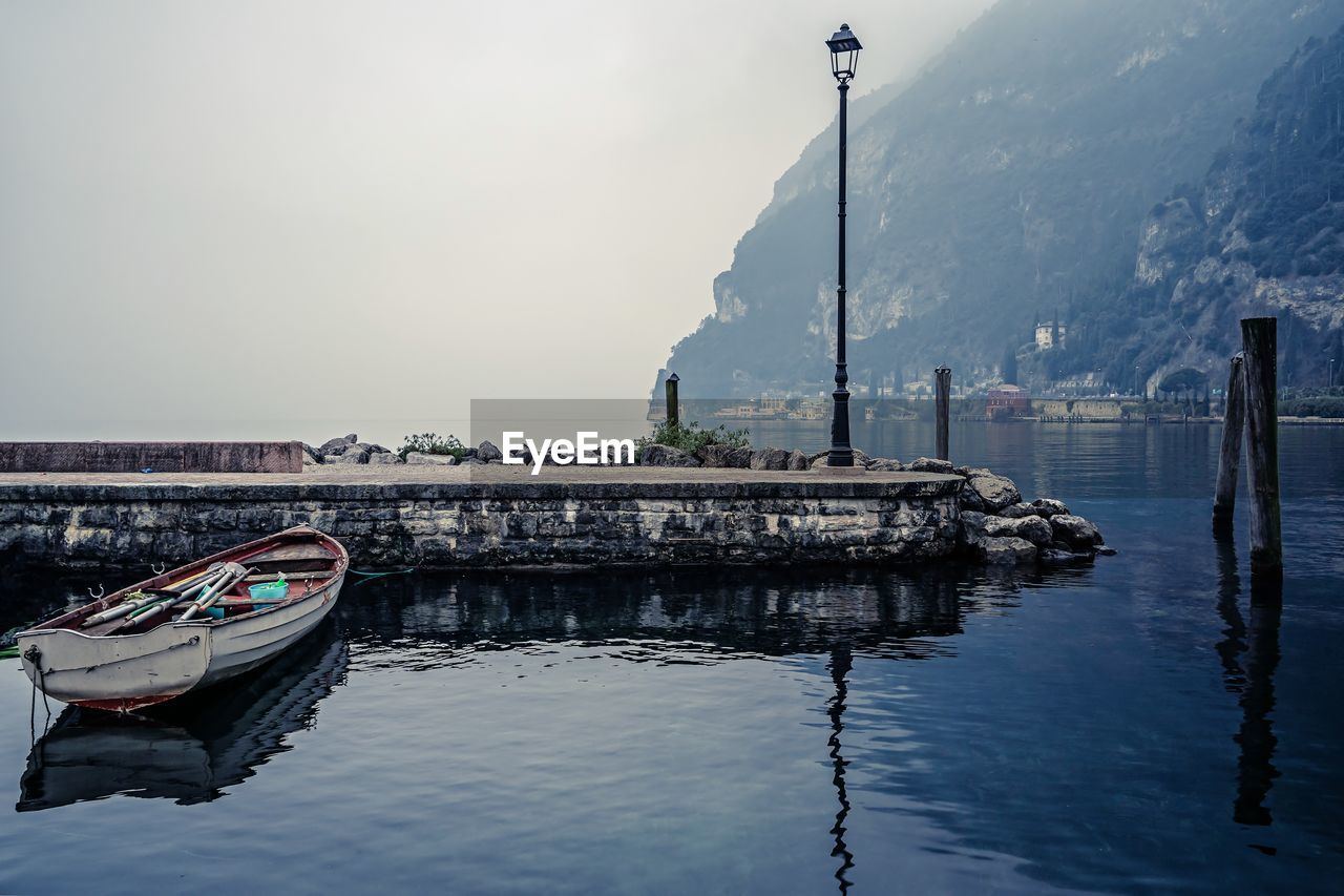 SHIP MOORED IN WATER AGAINST SKY