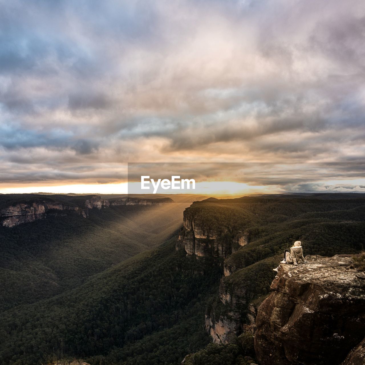 Scenic view of mountains against cloudy sky during sunset