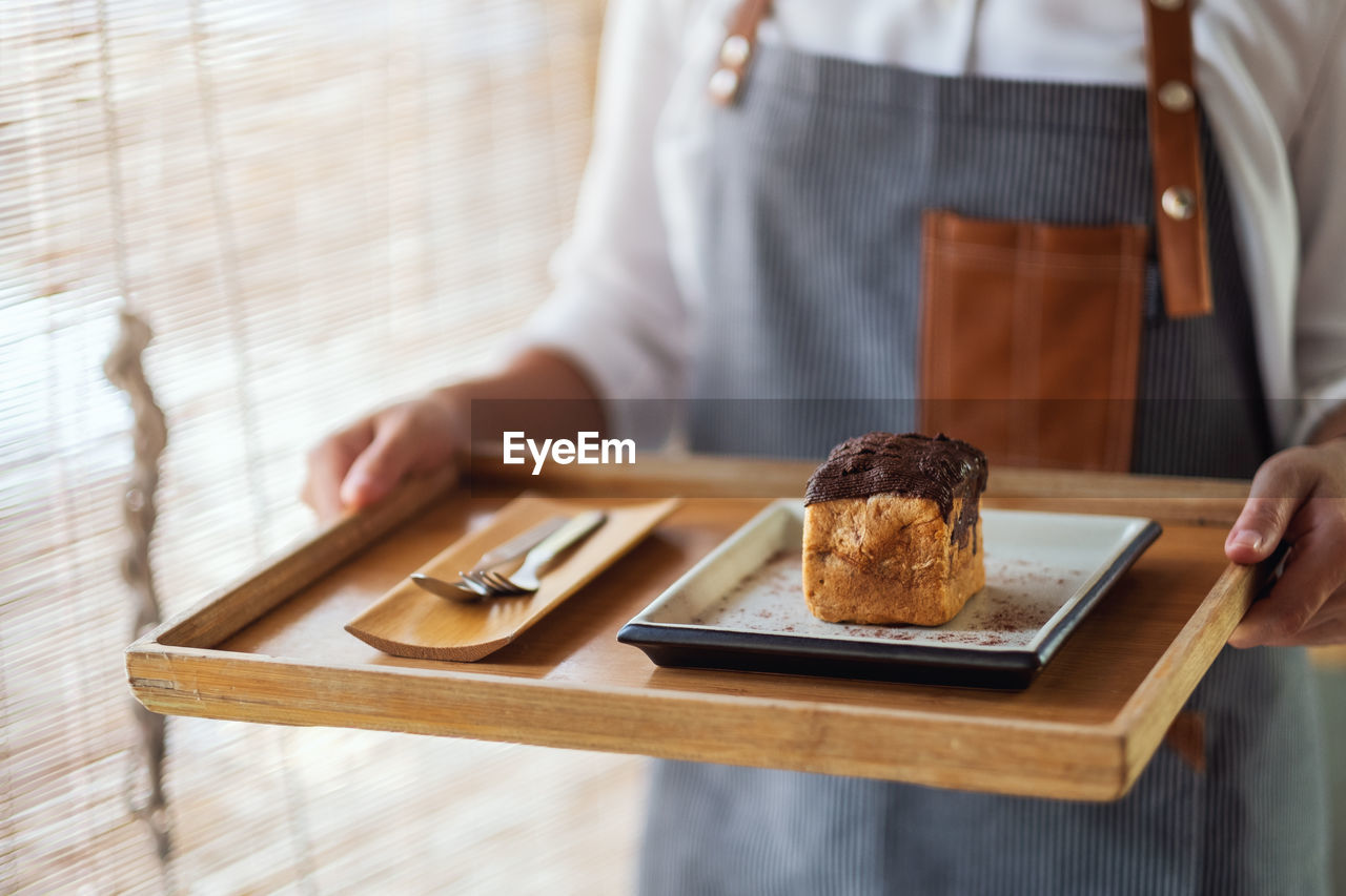 MIDSECTION OF MAN PREPARING FOOD IN PLATE