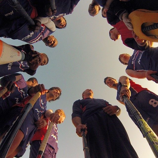 LOW ANGLE VIEW OF PEOPLE STANDING ON RAILING