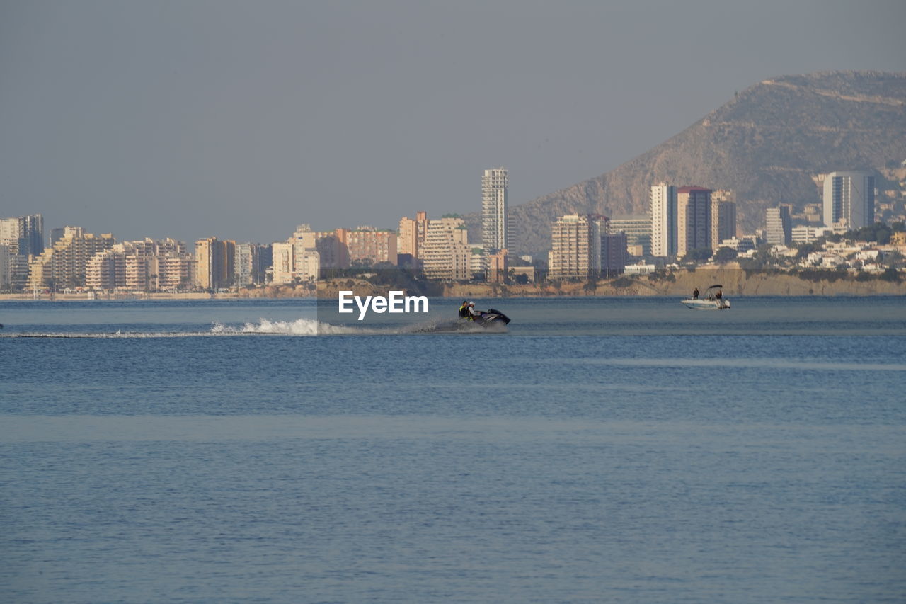 architecture, water, city, building exterior, horizon, built structure, building, sea, skyline, sky, coast, cityscape, travel destinations, landscape, nature, bay, urban skyline, office building exterior, ship, ocean, travel, vehicle, transportation, waterfront, skyscraper, nautical vessel, no people, shore, morning, dusk, outdoors, land, residential district, day, clear sky, scenics - nature, tourism, city life, beach, reflection, body of water, mode of transportation, snow