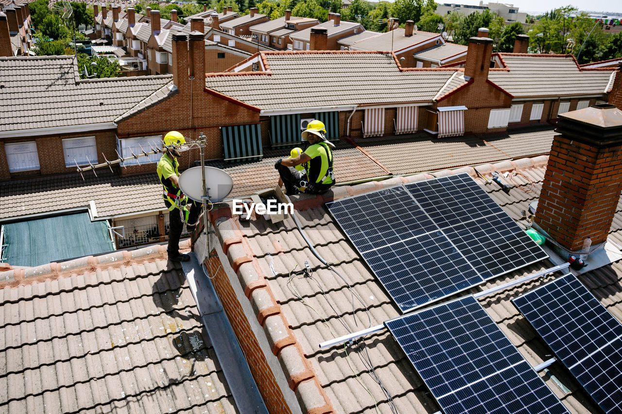 Engineers installing solar panels on roof