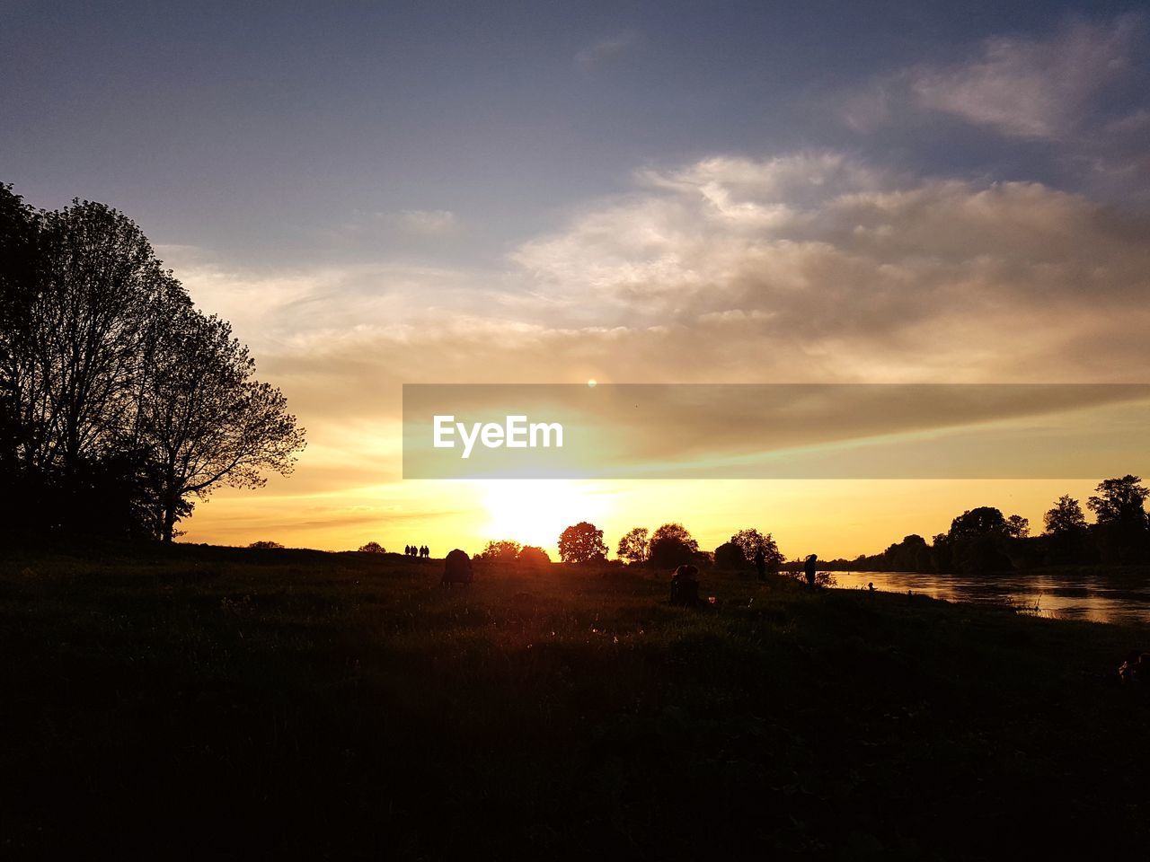 SCENIC VIEW OF SILHOUETTE FIELD AGAINST SKY AT SUNSET