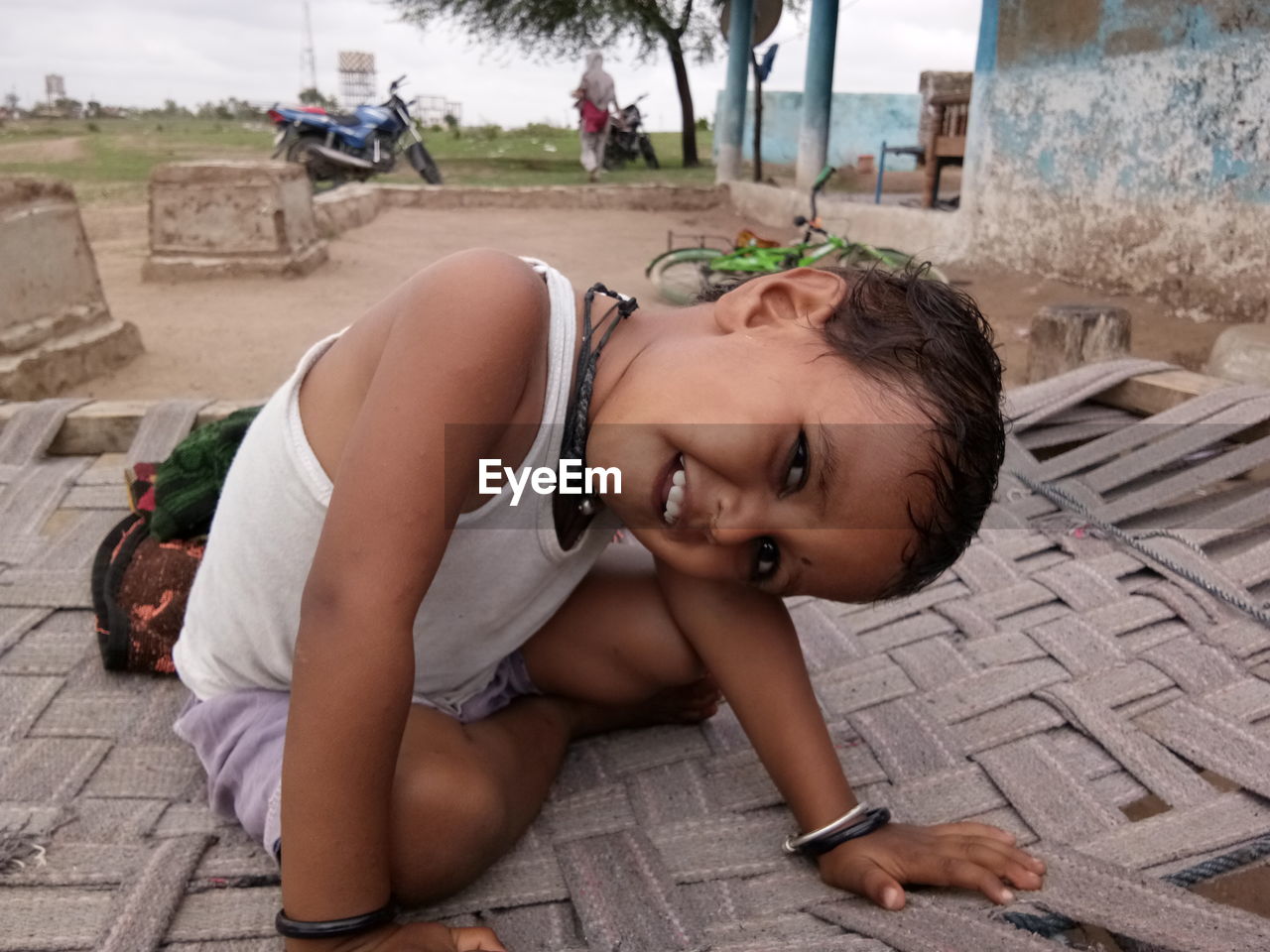 Portrait of boy sitting on bed outdoors