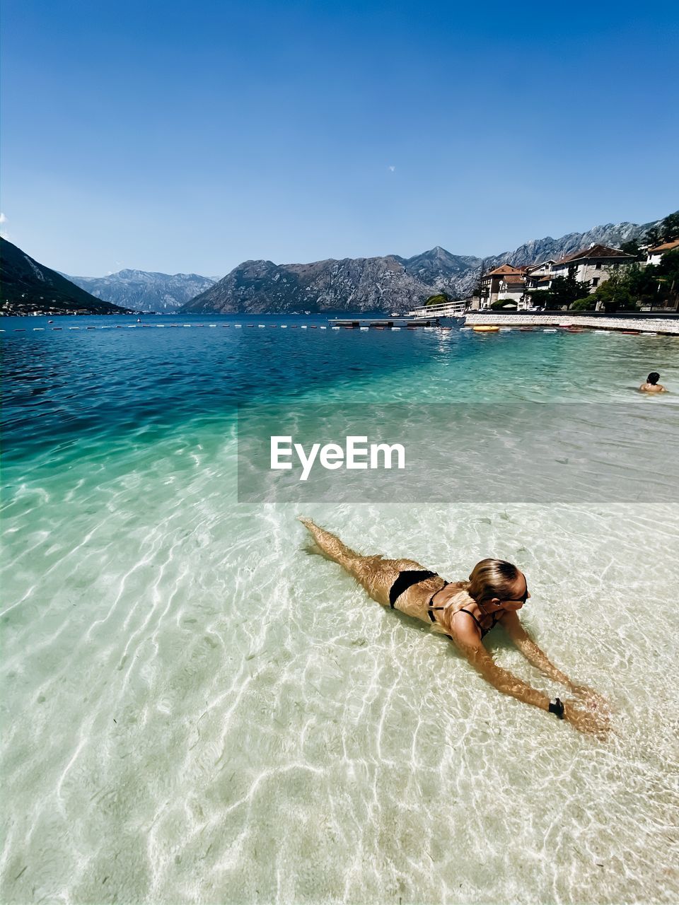 Women laying in the clear water on paradise beach 