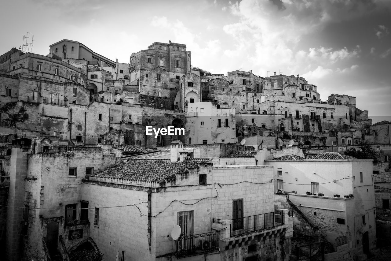 High angle view of old buildings in town against sky