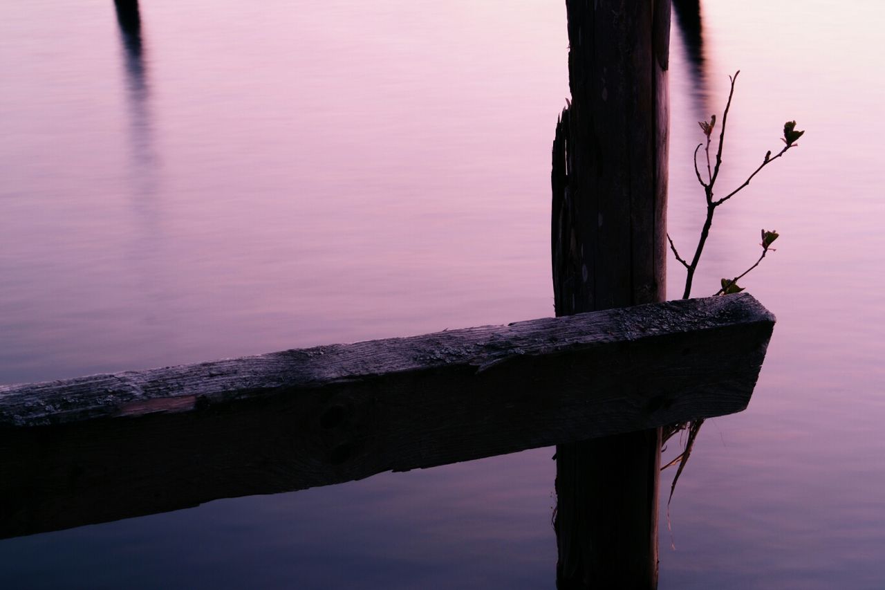 Close-up of wooden post against river