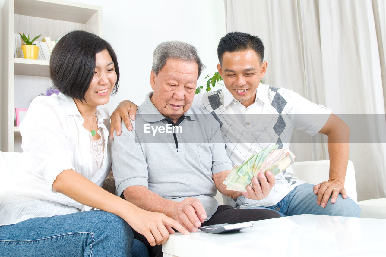 Family calculating paper currency at home