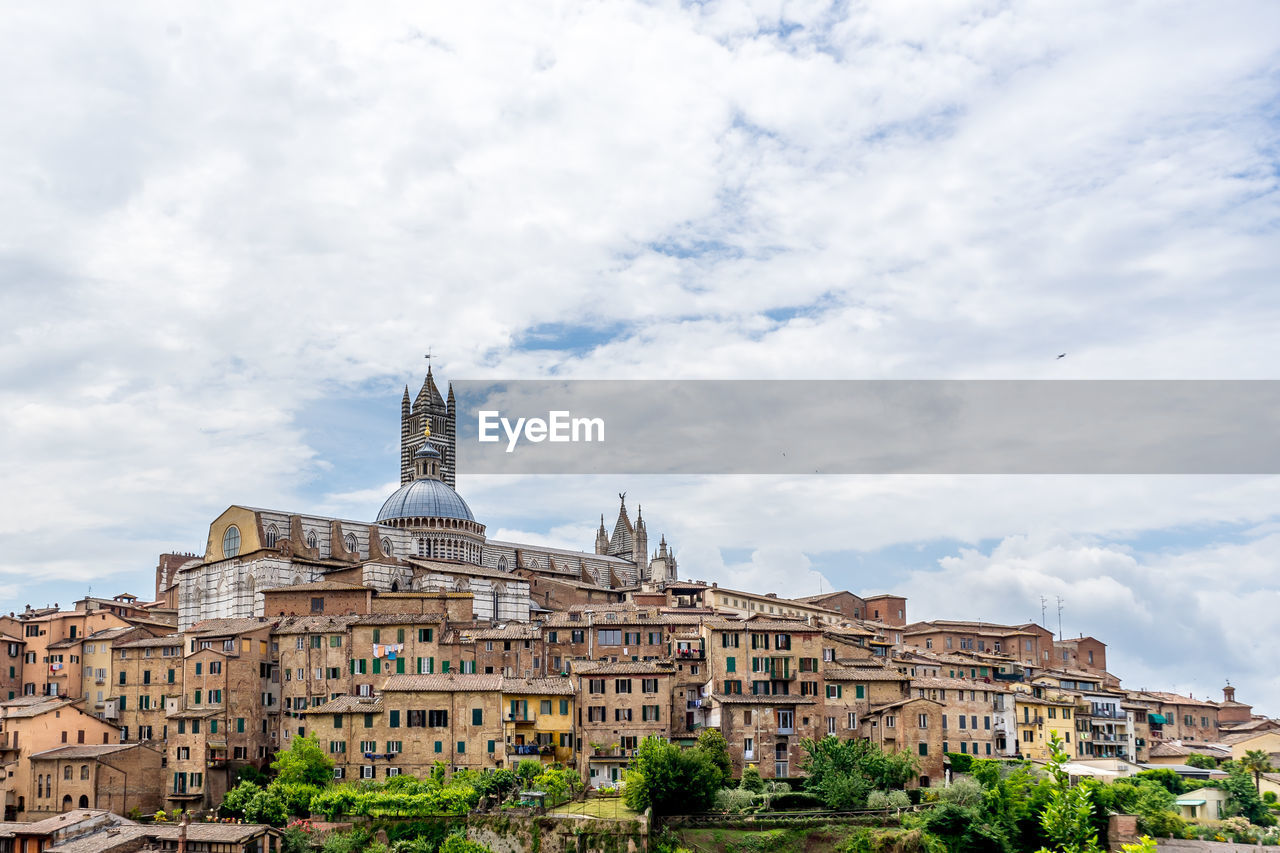Duomo di siena in city against cloudy sky