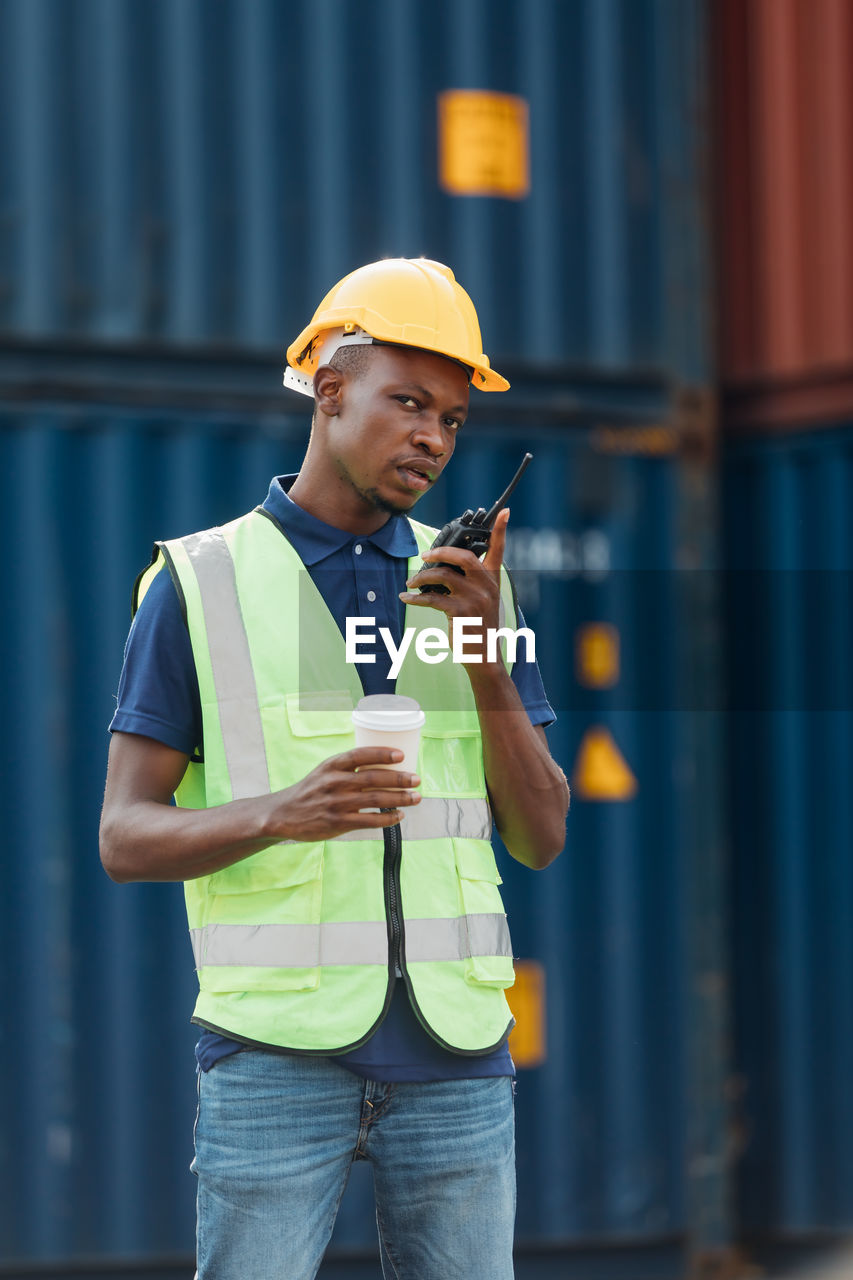 YOUNG MAN USING MOBILE PHONE WHILE STANDING ON CAMERA AT SMART