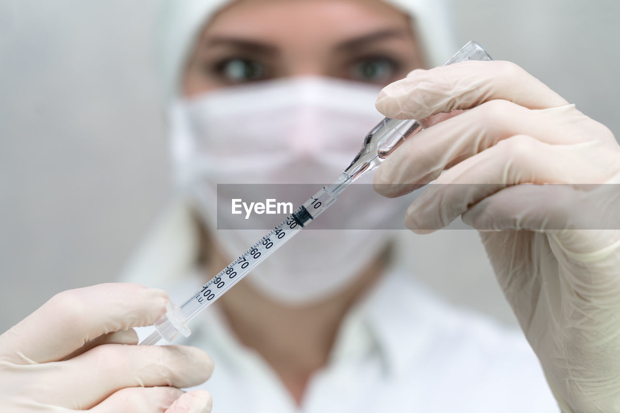 Girl picking medicine in a syringe closeup