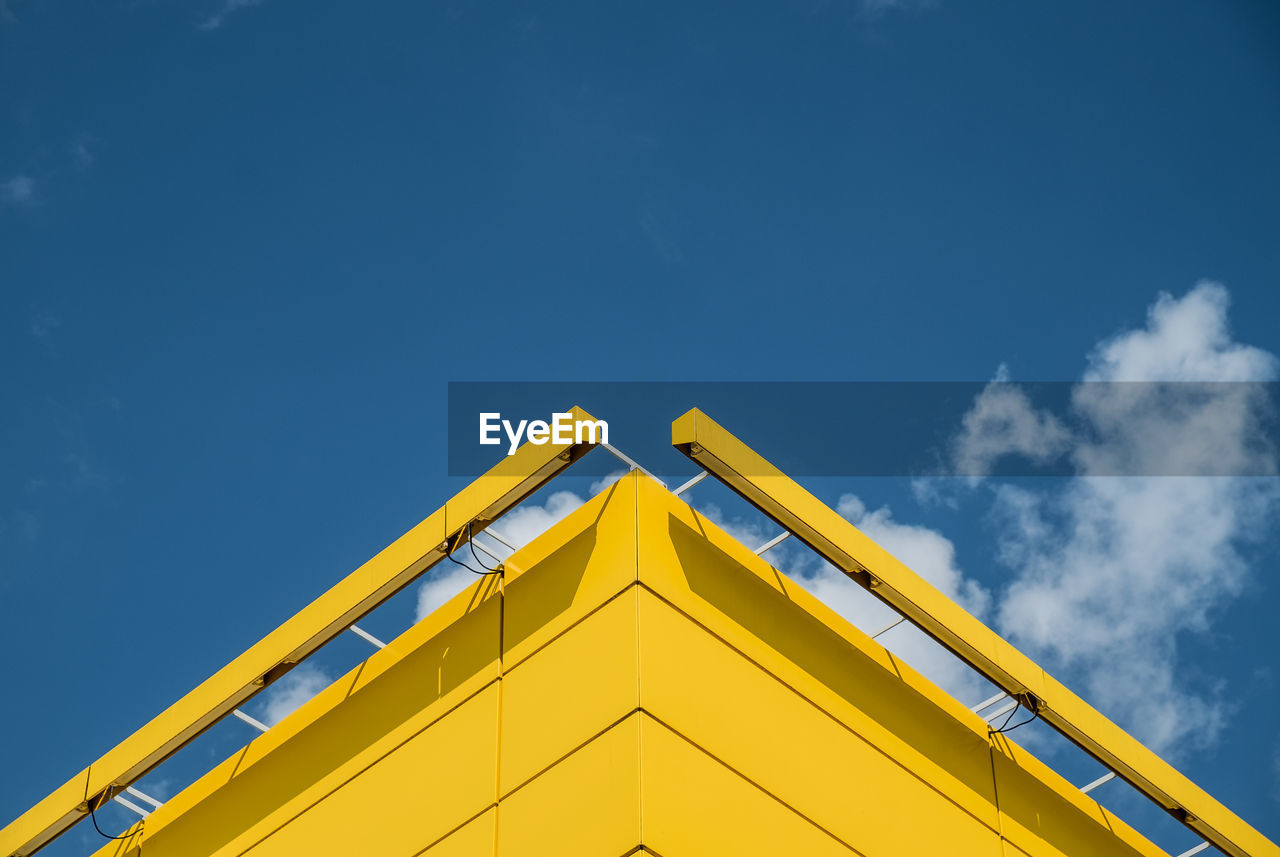 Low angle view of yellow built structure against blue sky