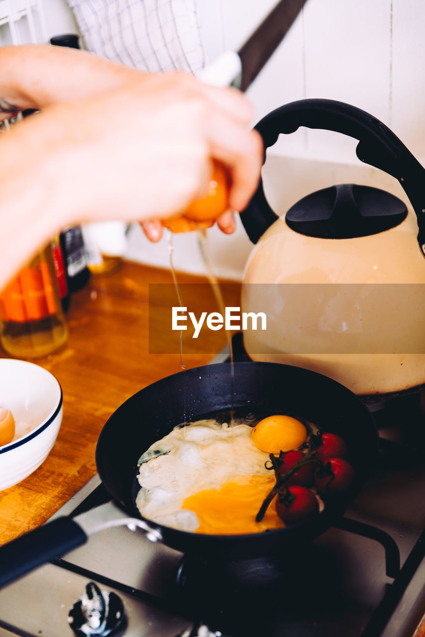 Cropped image hands preparing omelet in kitchen