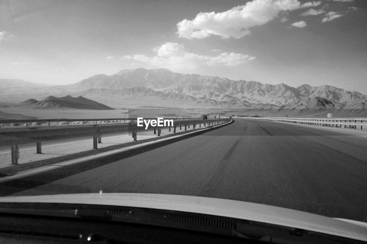 ROAD SEEN THROUGH CAR WINDSHIELD