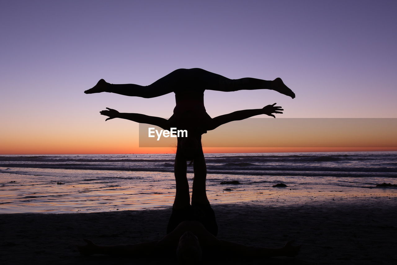 Silhouette man on beach against clear sky during sunset