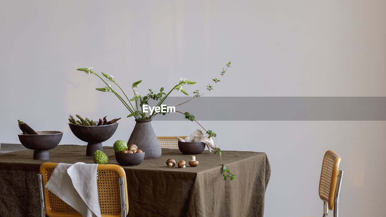 plant, indoors, table, no people, food and drink, nature, food, furniture, potted plant, flowerpot, art, houseplant, green, copy space, studio shot, growth, wood, freshness, seat, plant part, leaf, still life, arrangement, flower, chair, healthy eating, home interior, ikebana, wall - building feature, room, lifestyles, vase