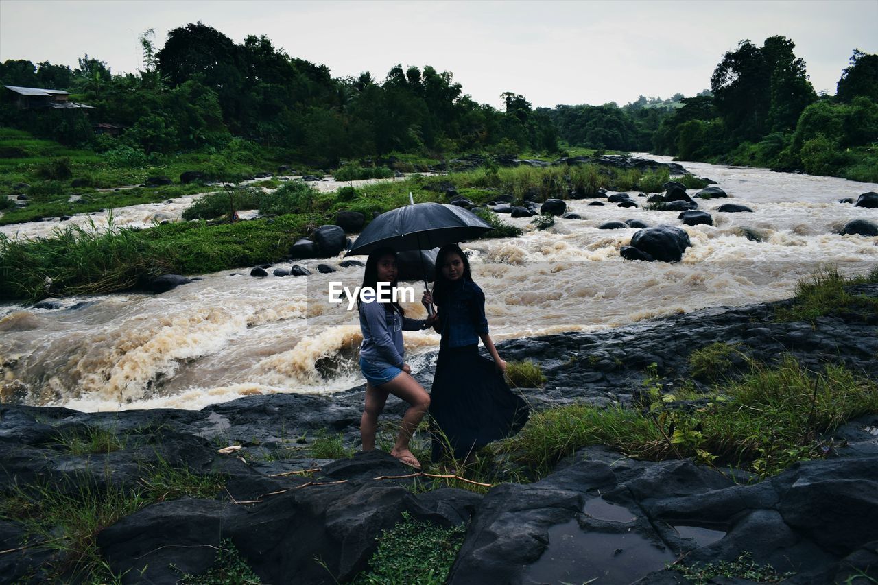 Friends standing by river