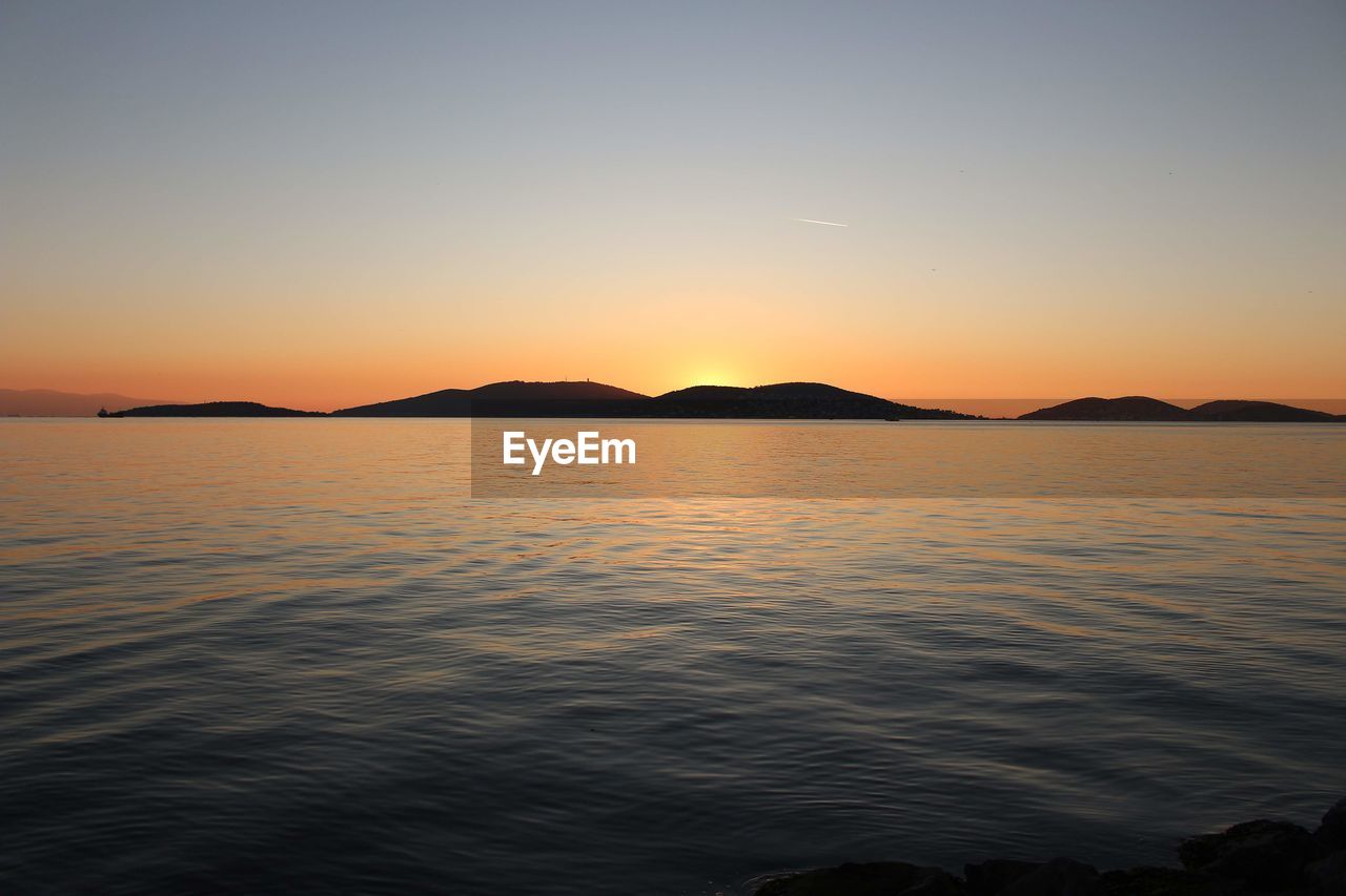 SCENIC VIEW OF SEA AGAINST SKY AT SUNSET