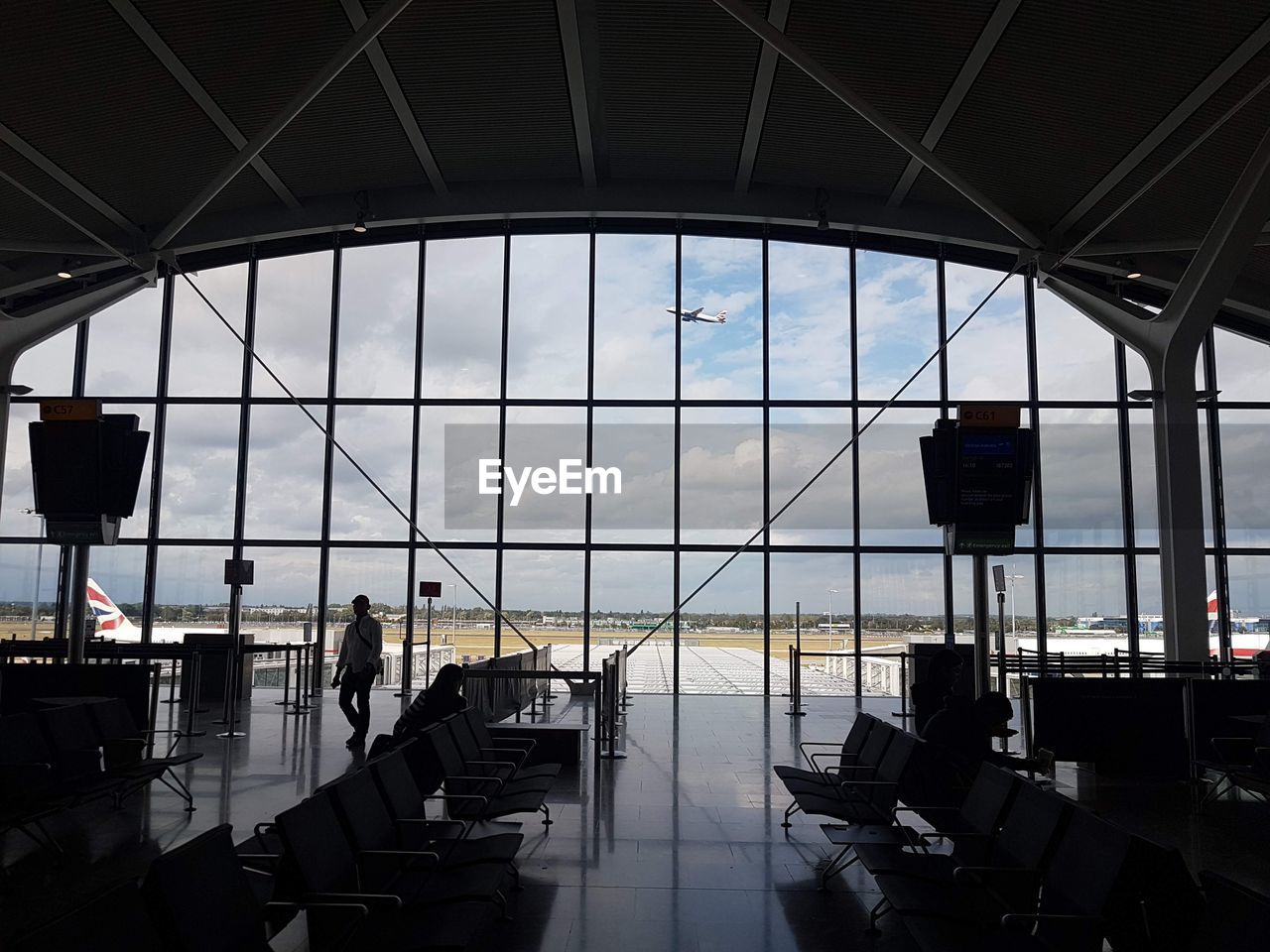 PEOPLE WAITING AT AIRPORT AGAINST SKY