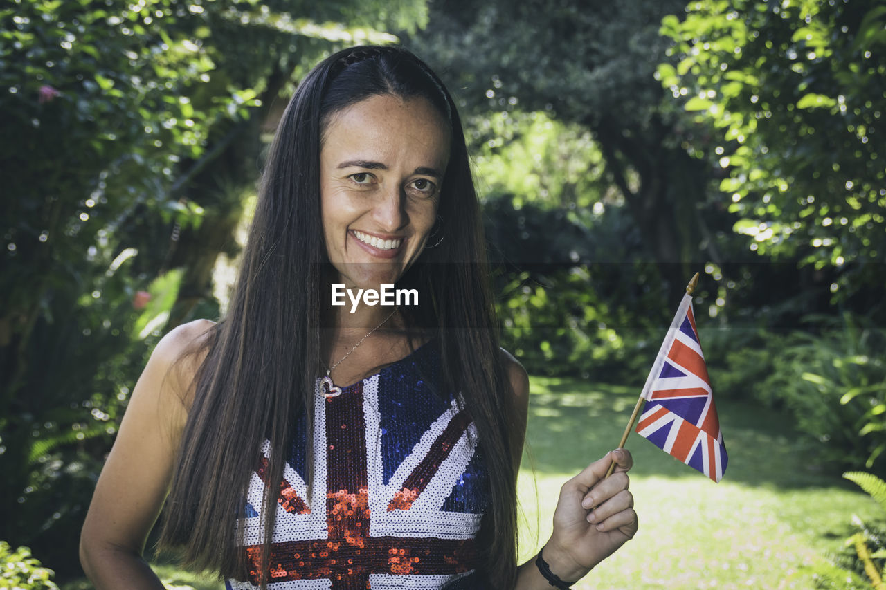 Beautiful woman holding up the union jack flag.