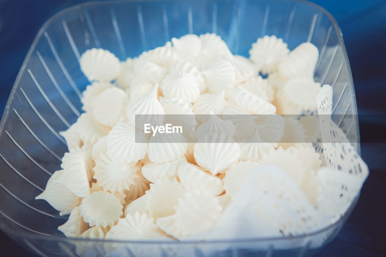Closeup shot of white fresh tender marshmallow zephyr in a glass plastic bowl dish on table