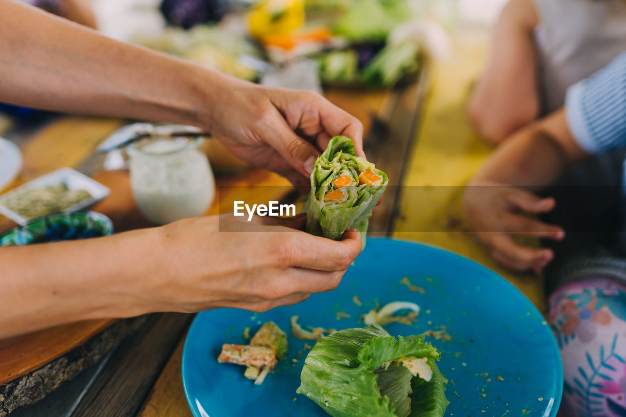 Cropped image of woman holding vegan lettuce wrap