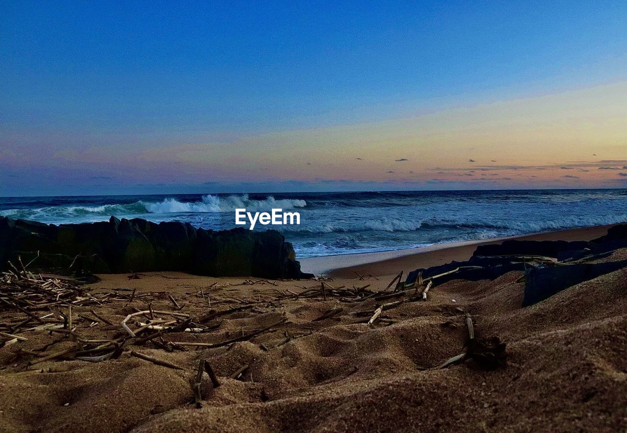 SCENIC VIEW OF BEACH DURING SUNSET