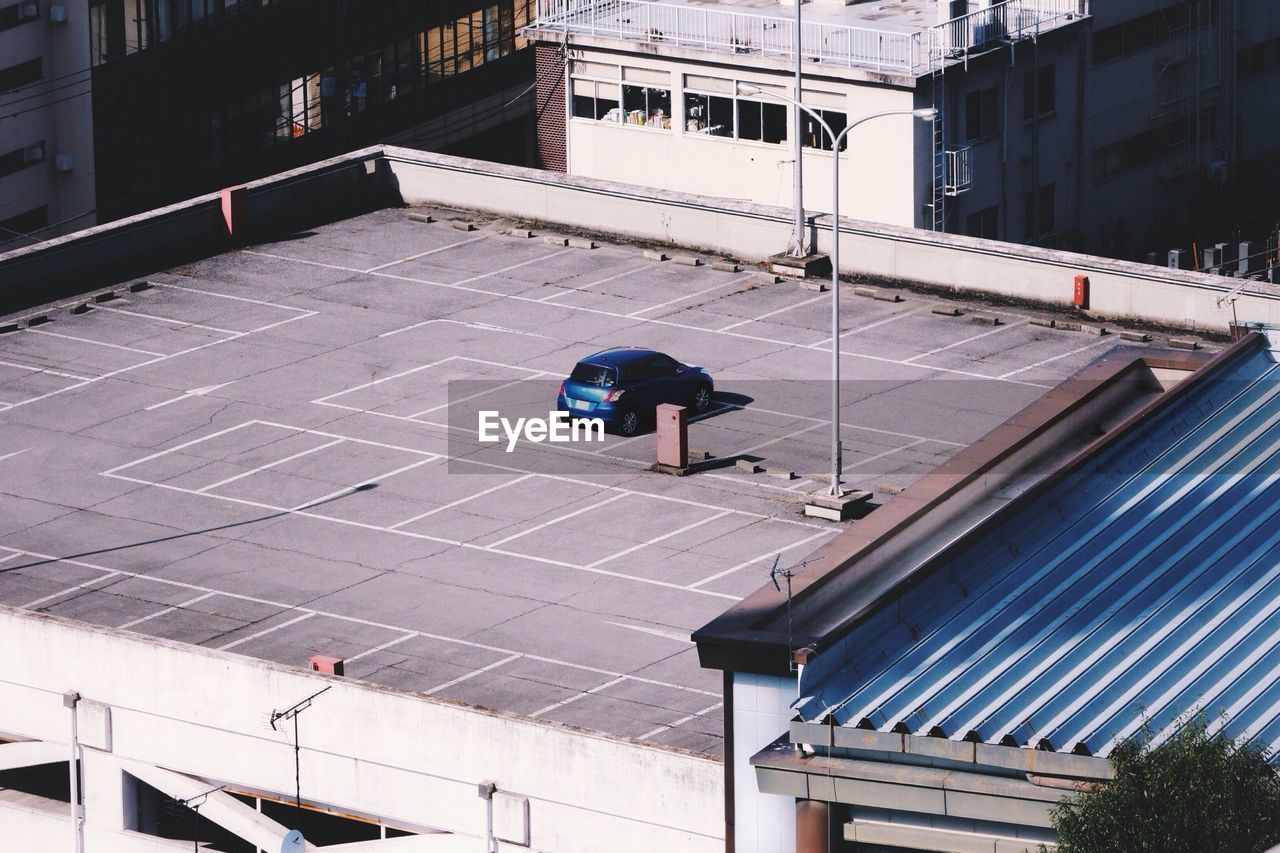High angle view of car parked in parking lot of building terrace