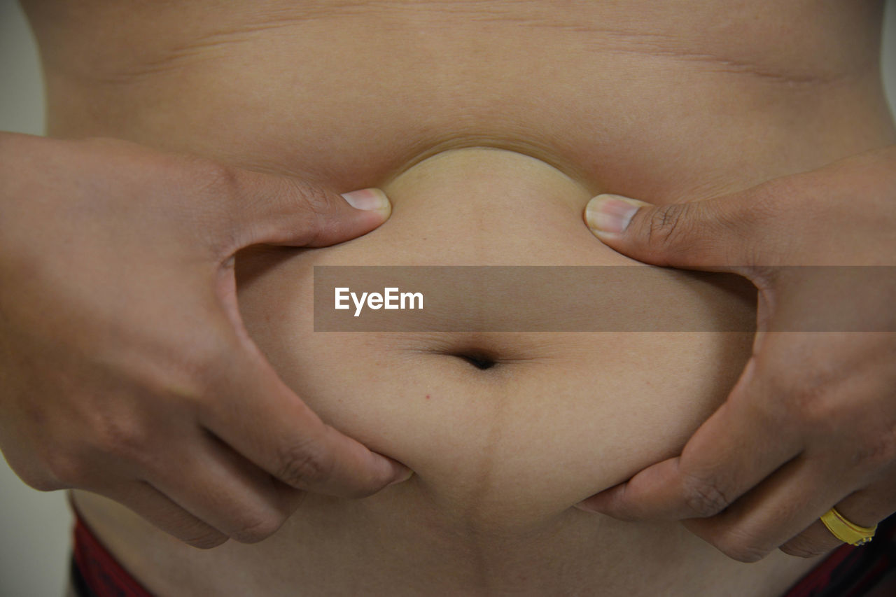 Midsection of man with hand on stomach