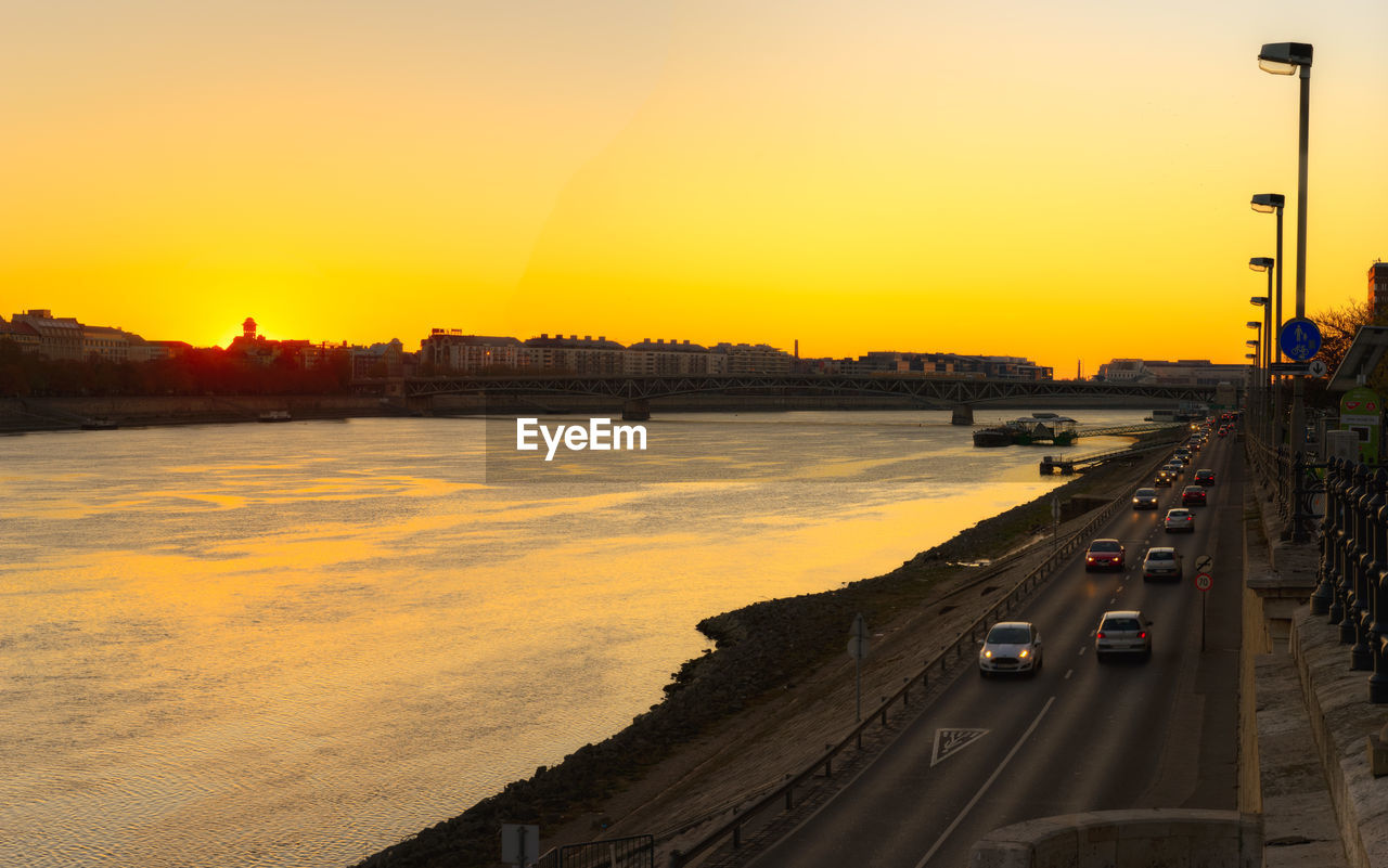 High angle view of cars on liberty bridge by river during sunrise