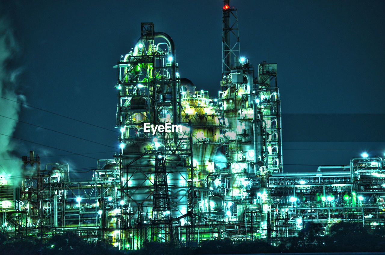 LOW ANGLE VIEW OF ILLUMINATED BUILDINGS AT NIGHT