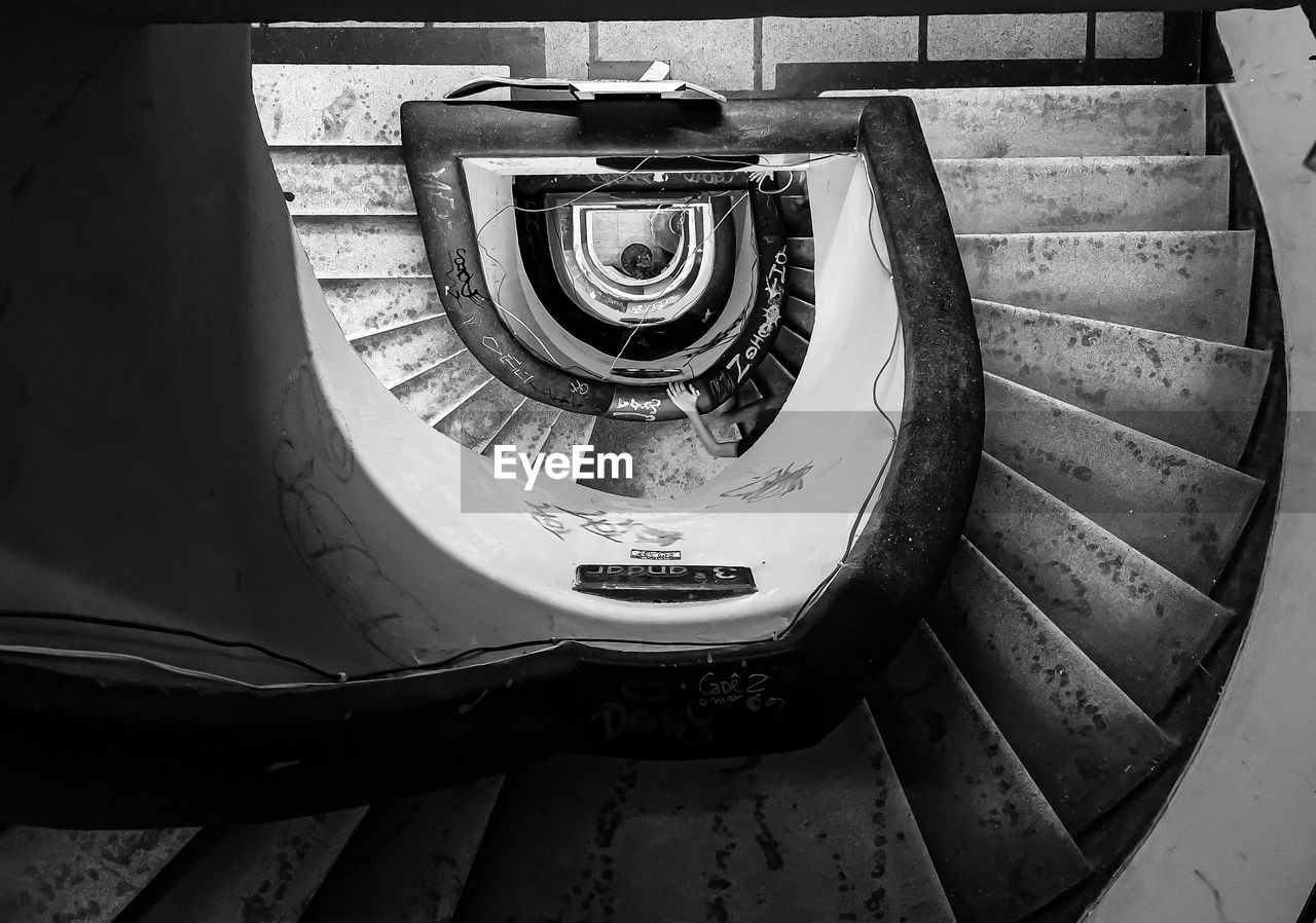 black, steps and staircases, staircase, spiral staircase, white, spiral, railing, black and white, monochrome, wheel, architecture, monochrome photography, light, indoors, built structure, darkness, camera, high angle view, no people, stairs