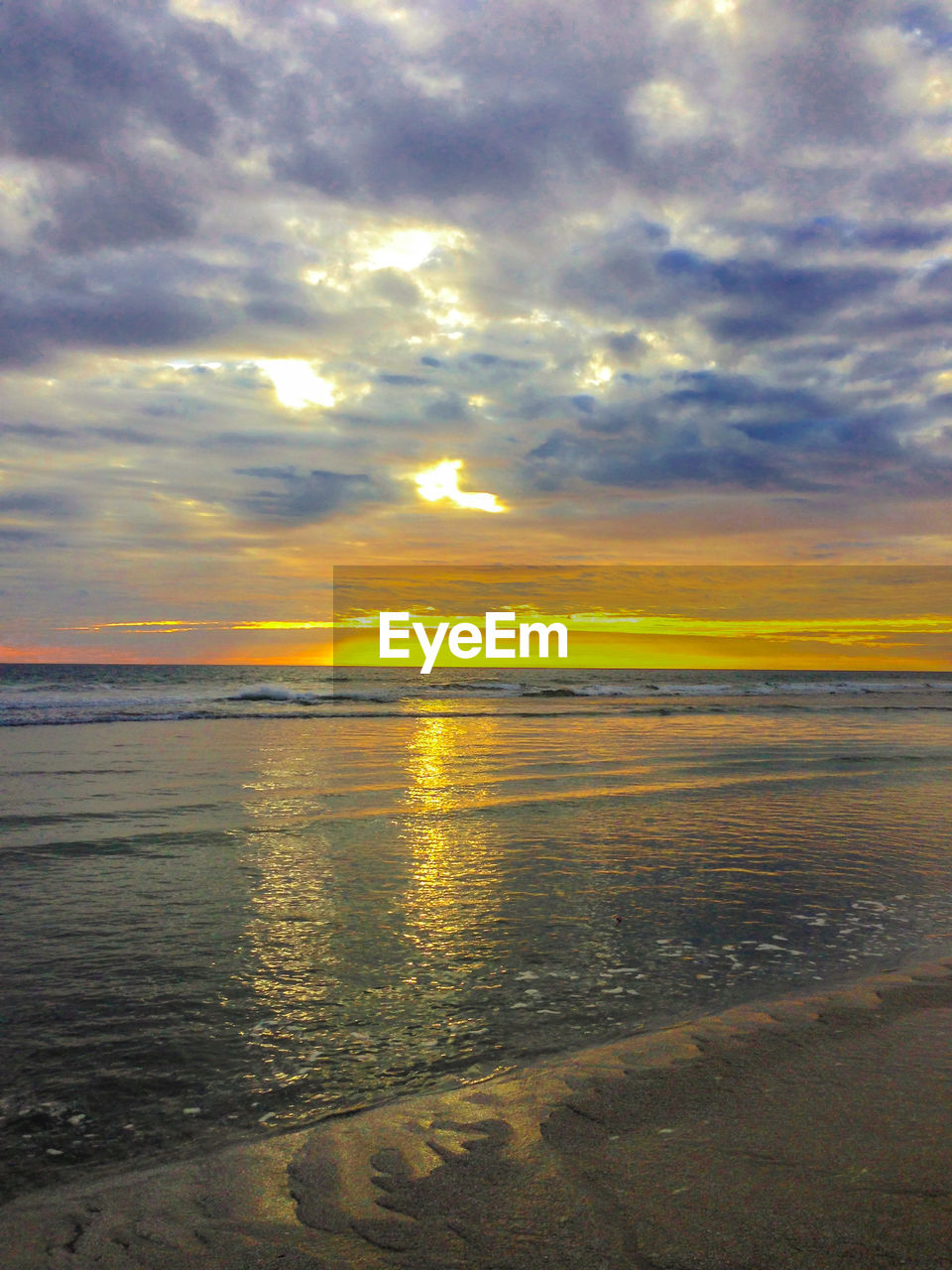 SCENIC VIEW OF BEACH AGAINST DRAMATIC SKY