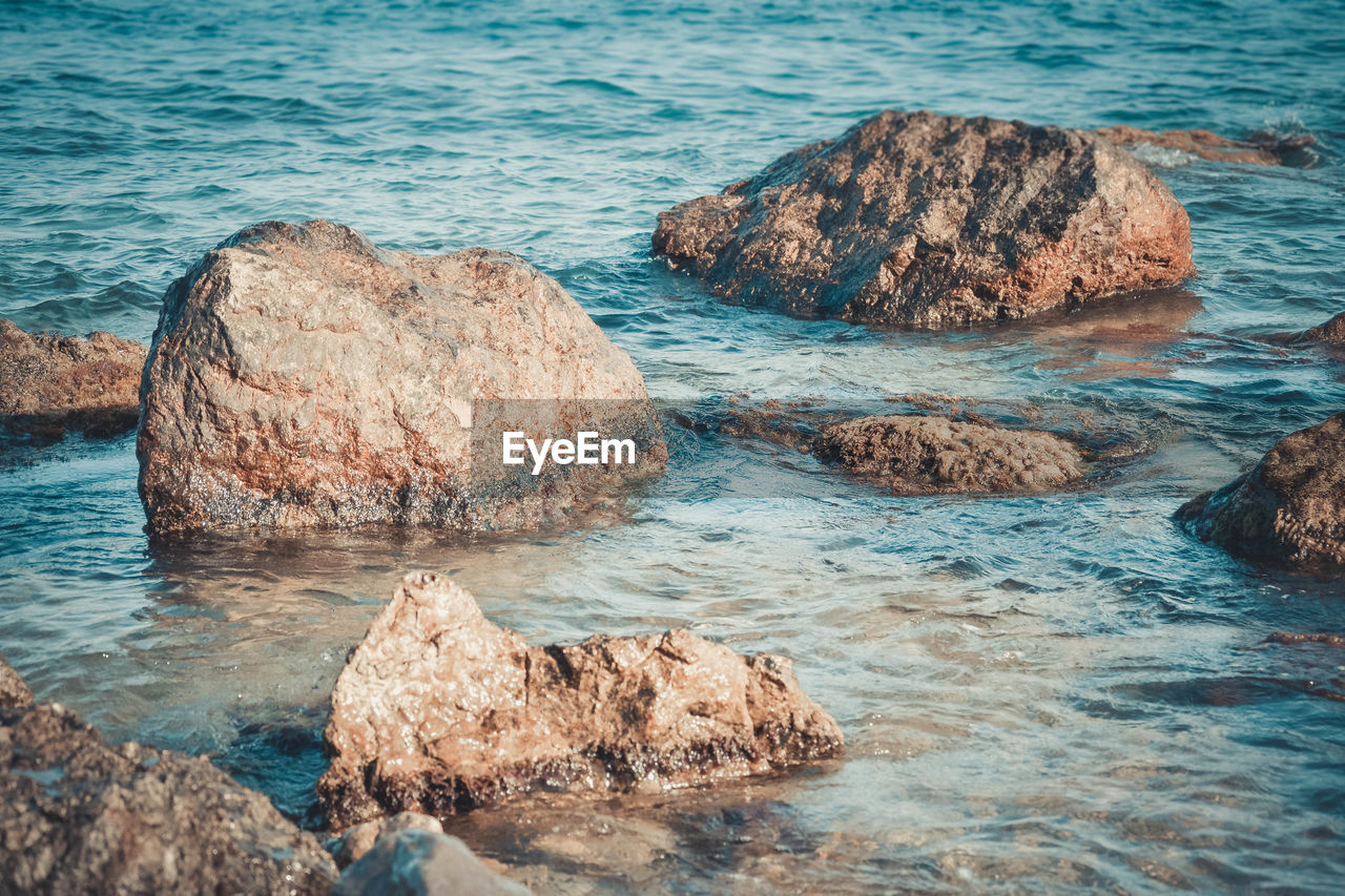 HIGH ANGLE VIEW OF ROCKS ON SHORE