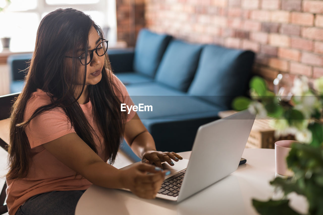 young woman using laptop while sitting at home